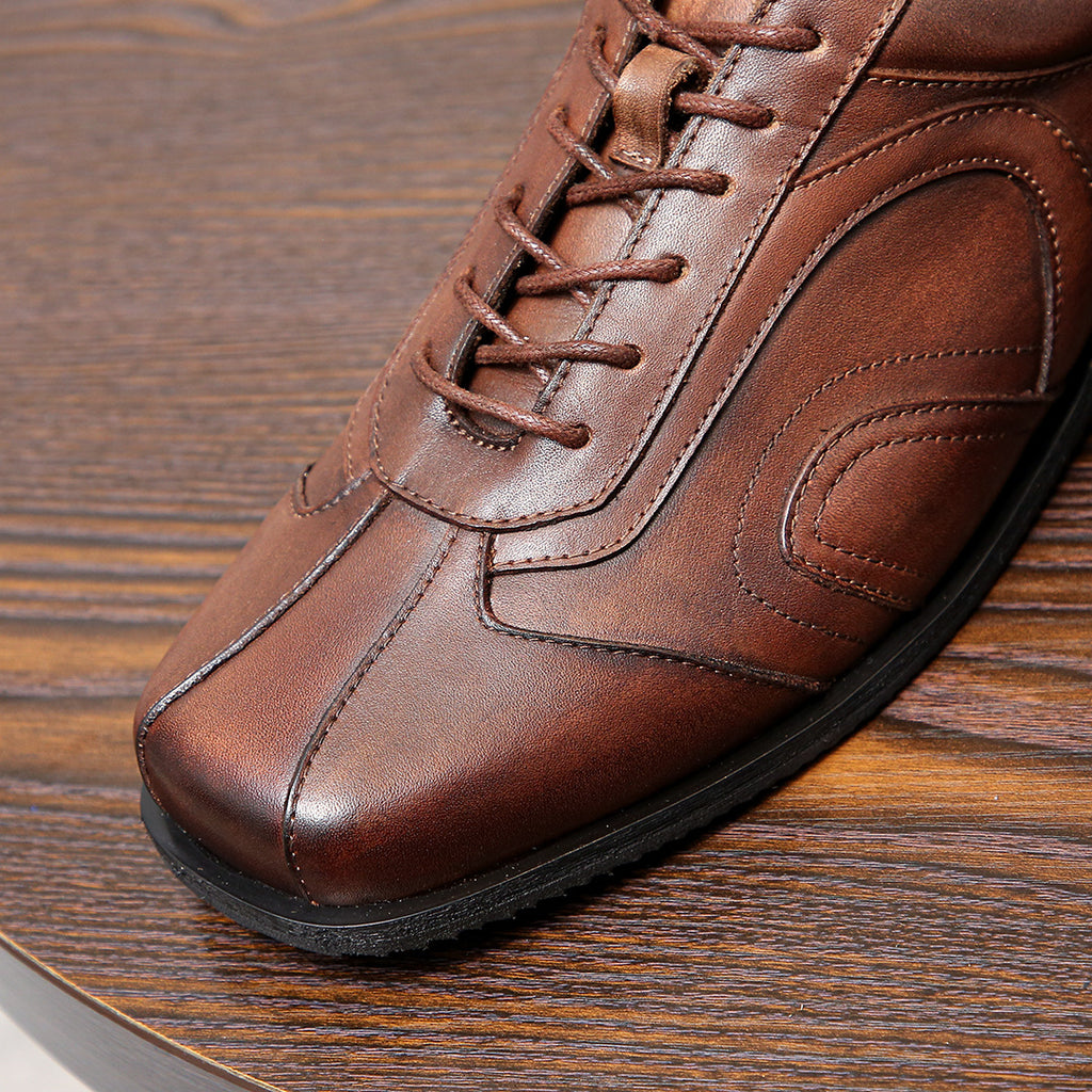 Men's brown leather sneaker close-up with lace eyelets and contrast stitching