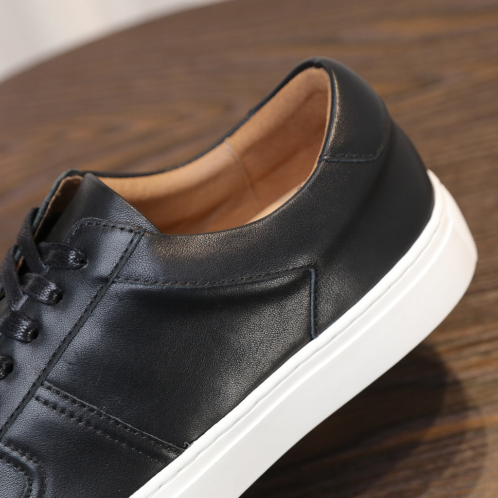Close-up of black leather sneaker upper and padded collar with white midsole