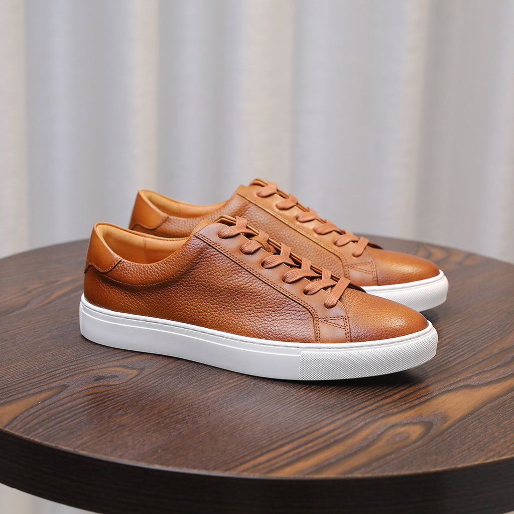 Brown leather lace-up sneakers with tan laces, white side stripe, and white sole