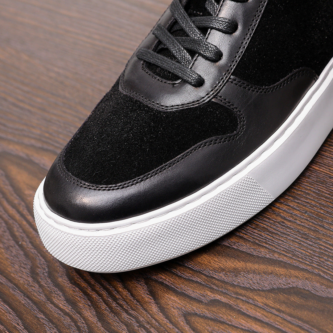 Black leather sneakers close-up: textured suede panel, lace eyelets, white midsole
