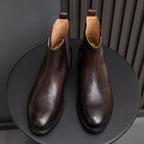 Pointed-toe Chelsea boots, dark brown, front view with elastic side panels