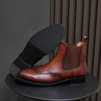 Men's pointed-toe Chelsea dress boots in dark brown, showing heel and outsole