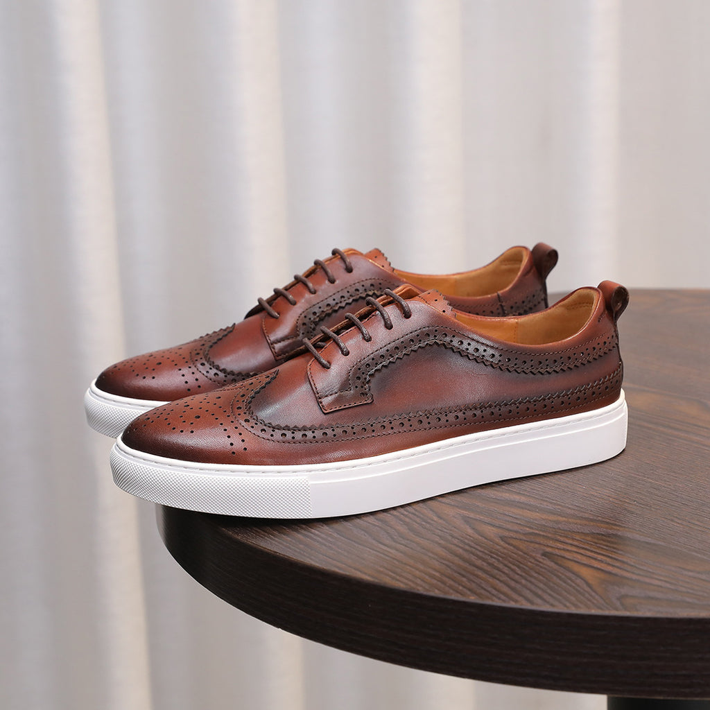 Brown leather sneakers, lace-up with brogue-style perforations and white sole