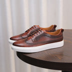 Brown leather sneakers, lace-up with brogue-style perforations and white sole