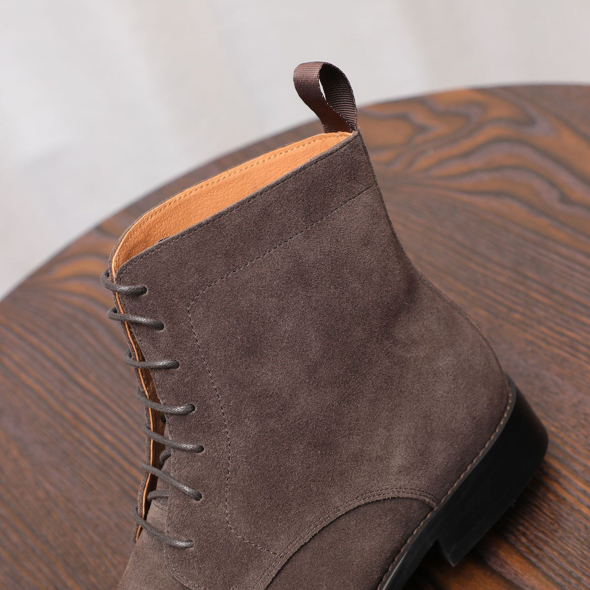 Dark brown suede chukka boot with lace-up closure and padded ankle collar