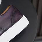 Dark purple leather sneaker side with white platform sole and contrast stitching