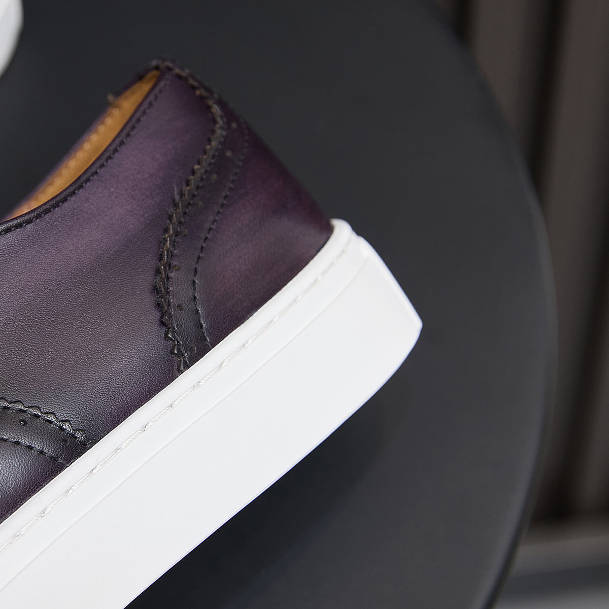 Dark purple leather sneaker side with white platform sole and contrast stitching