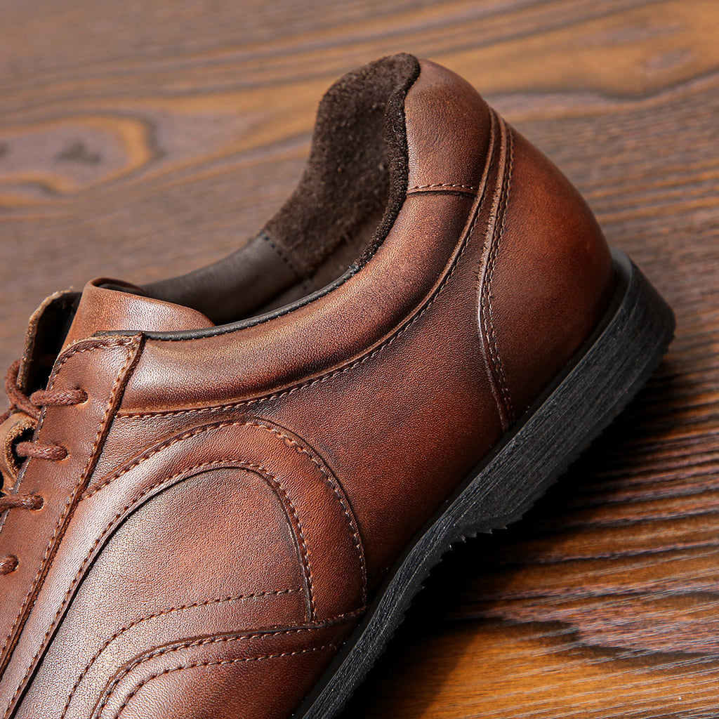 Men's brown leather sneaker heel close-up with padded collar and lace eyelets