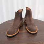 Pair of dark brown suede chelsea boots with pointed toe, elastic side gores