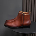 Men's pointed-toe leather dress boot with side zip, brown leather and black outsole.