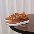 Men's brown suede leather sneakers with lace-up eyelets and white rubber sole.