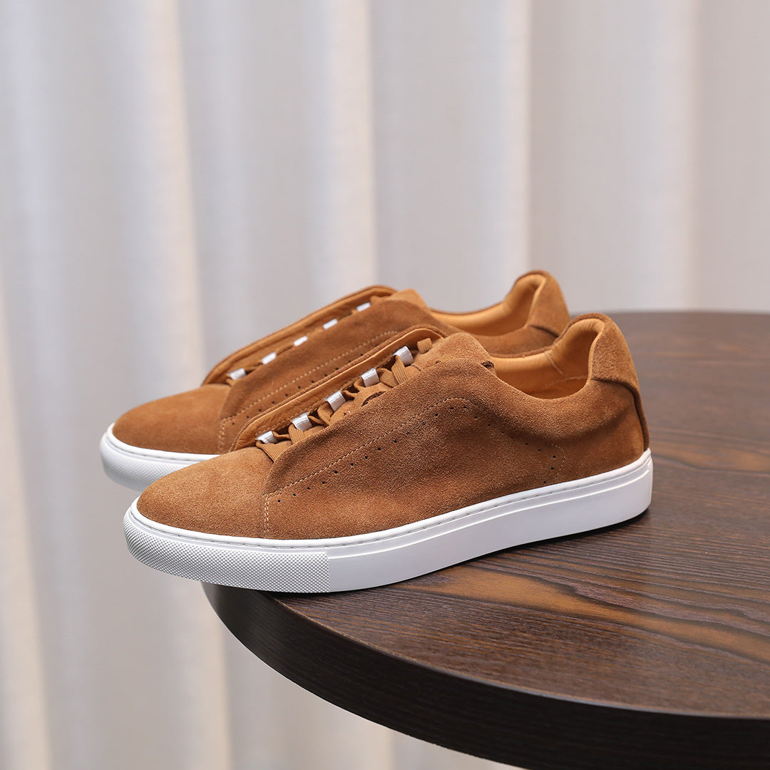 Men's brown suede leather sneakers with lace-up eyelets and white rubber sole.