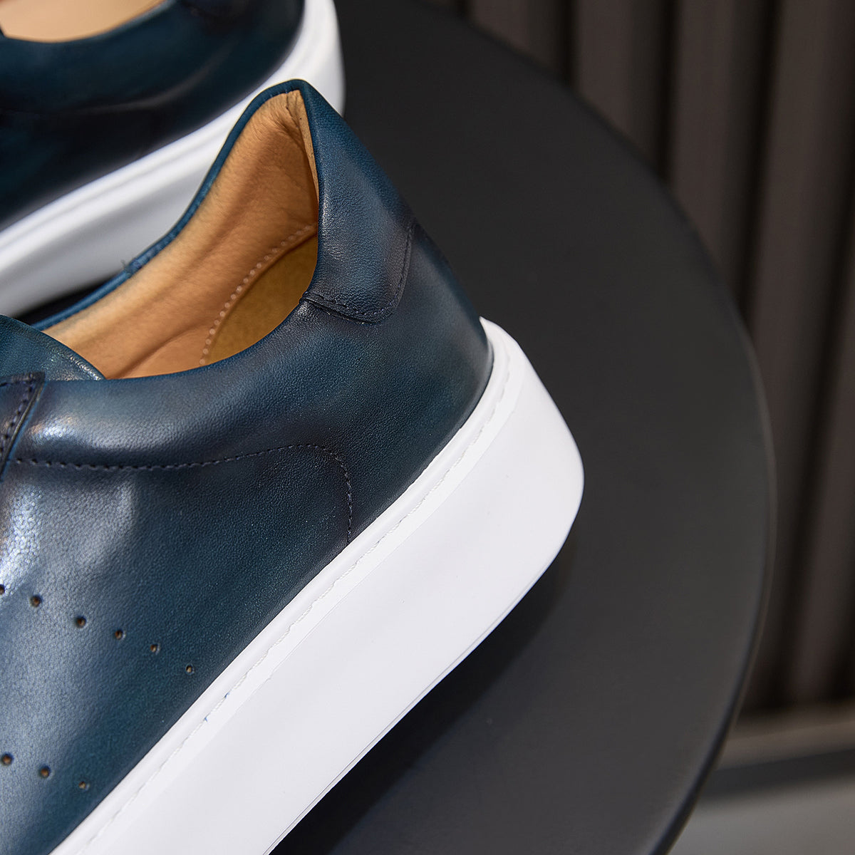 Blue leather sneaker heel and collar with white stitching and white sole