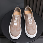 Light taupe leather sneakers pair with white laces and thick white rubber sole