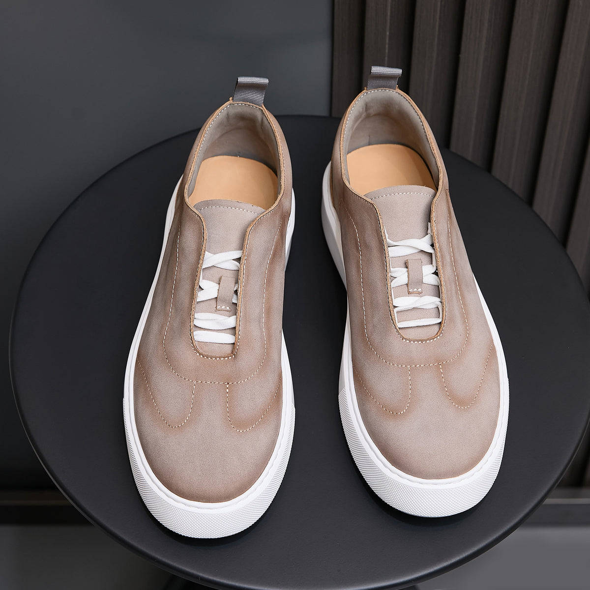 Light taupe leather sneakers pair with white laces and thick white rubber sole