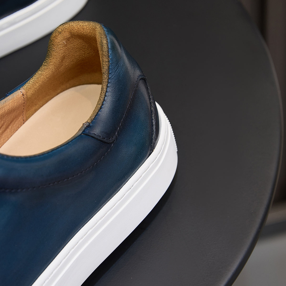 Blue leather sneaker with tan interior lining and padded collar, white sole edge
