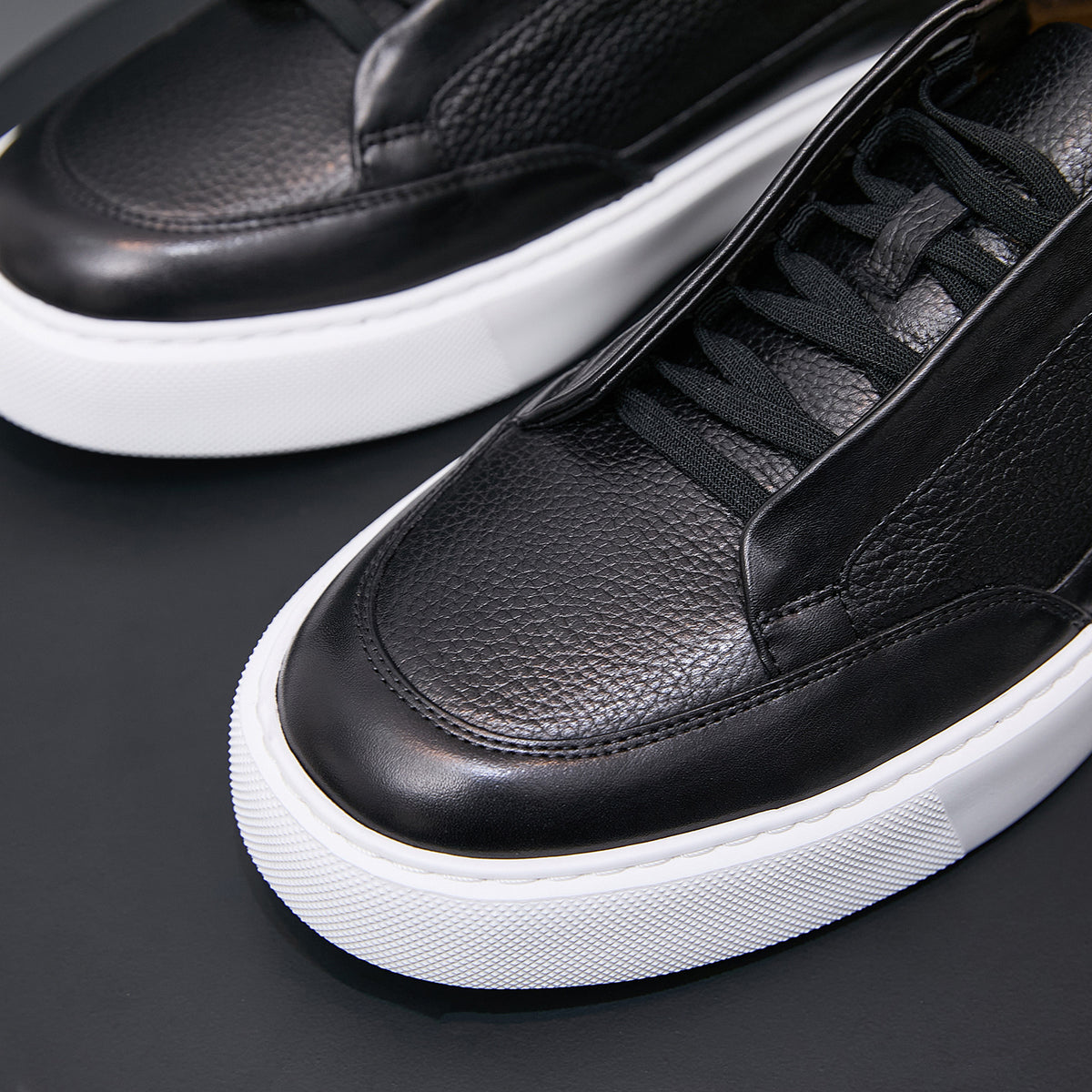 Men's genuine leather sneakers in black, close-up of laces, stitching, and white sole.