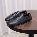 Men's black leather sneakers with textured finish, lace-up front, and gum sole