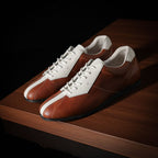 Brown and white leather sneakers with lace-up front and contrasting side stripe.