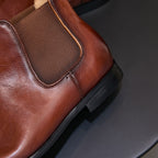 Brown pointed-toe Chelsea dress boot with elastic gore and textured upper detail