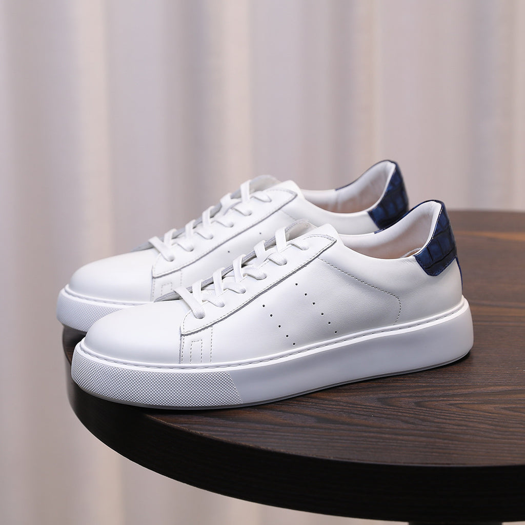 Men's white leather low-top sneakers with lace-up, blue heel accents, and white sole