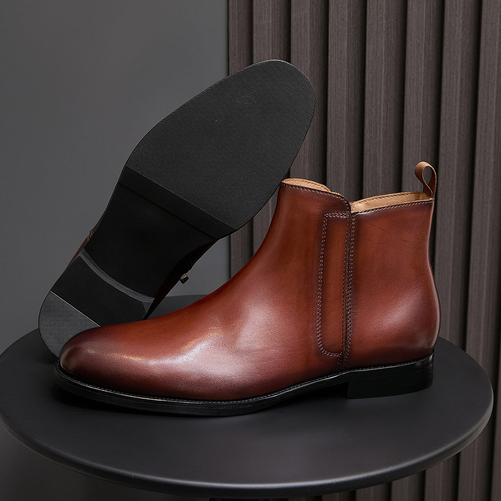 Men's pointed-toe leather dress boot with side zip, brown leather and black sole.