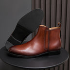 Men's pointed-toe leather dress boot with side zip, brown leather and black sole.