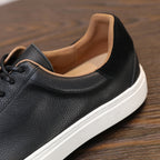 Men's black leather sneaker with padded collar, tan lining, and white platform sole.