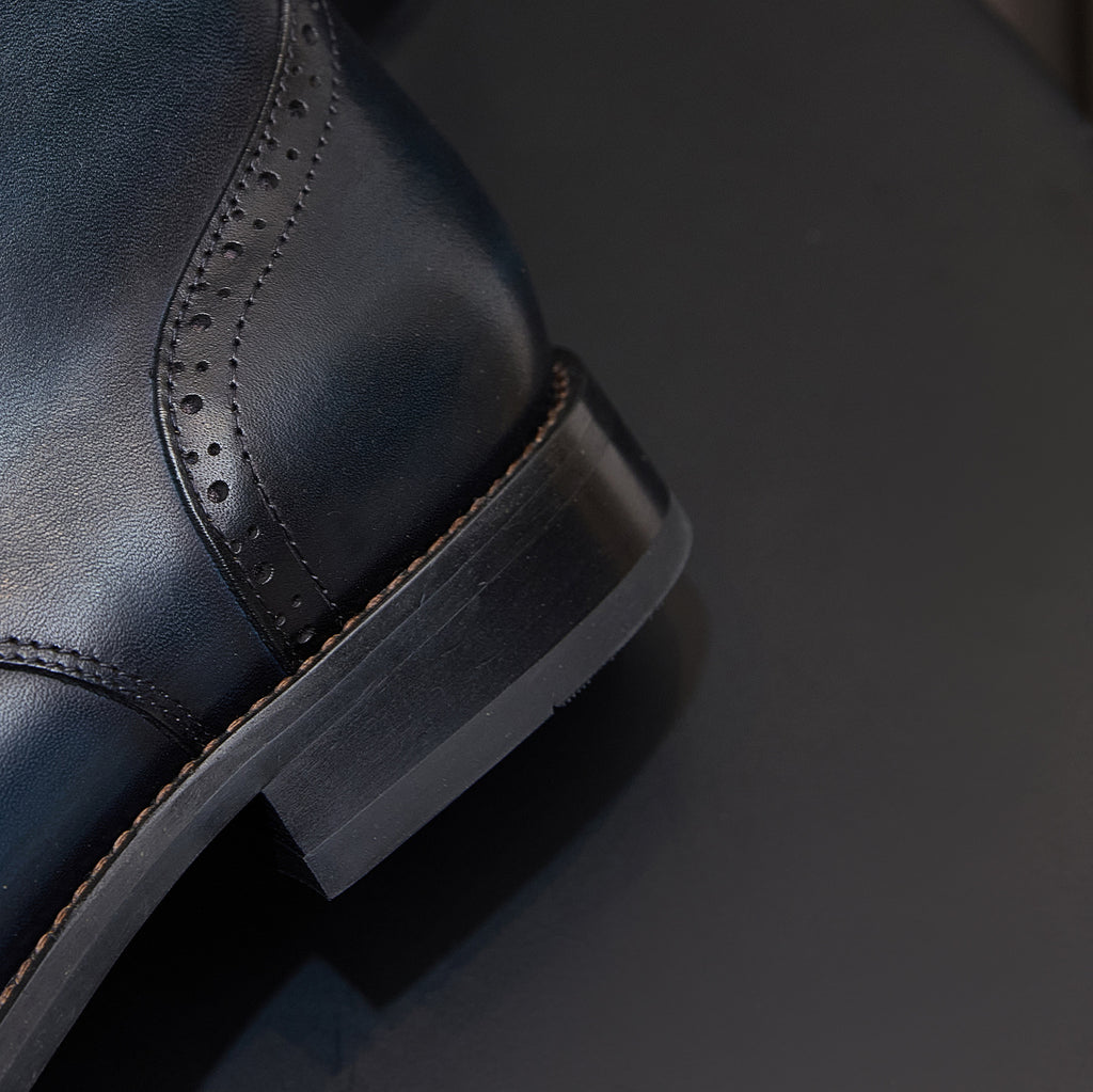 Men's leather dress boot with pointed toe and stitched wing detailing on the upper