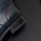Men's leather dress boot with pointed toe and stitched wing detailing on the upper
