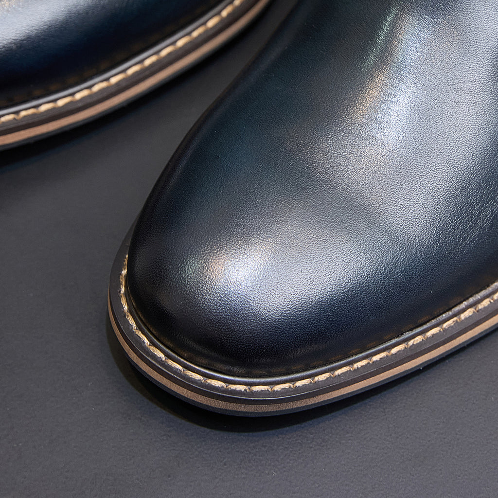 Close-up of pointed toe and sole on dark blue Chelsea dress boots with contrast stitching