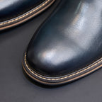 Close-up of pointed toe and sole on dark blue Chelsea dress boots with contrast stitching
