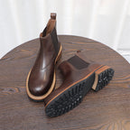 Dark brown Chelsea dress boots showing treaded rubber sole and pull-on elastic sides