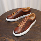 Men's brown genuine leather sneakers, pair view with tan laces and white rubber sole.