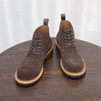 Pair of dark brown suede chukka boots with lace-up front and tan-trimmed sole