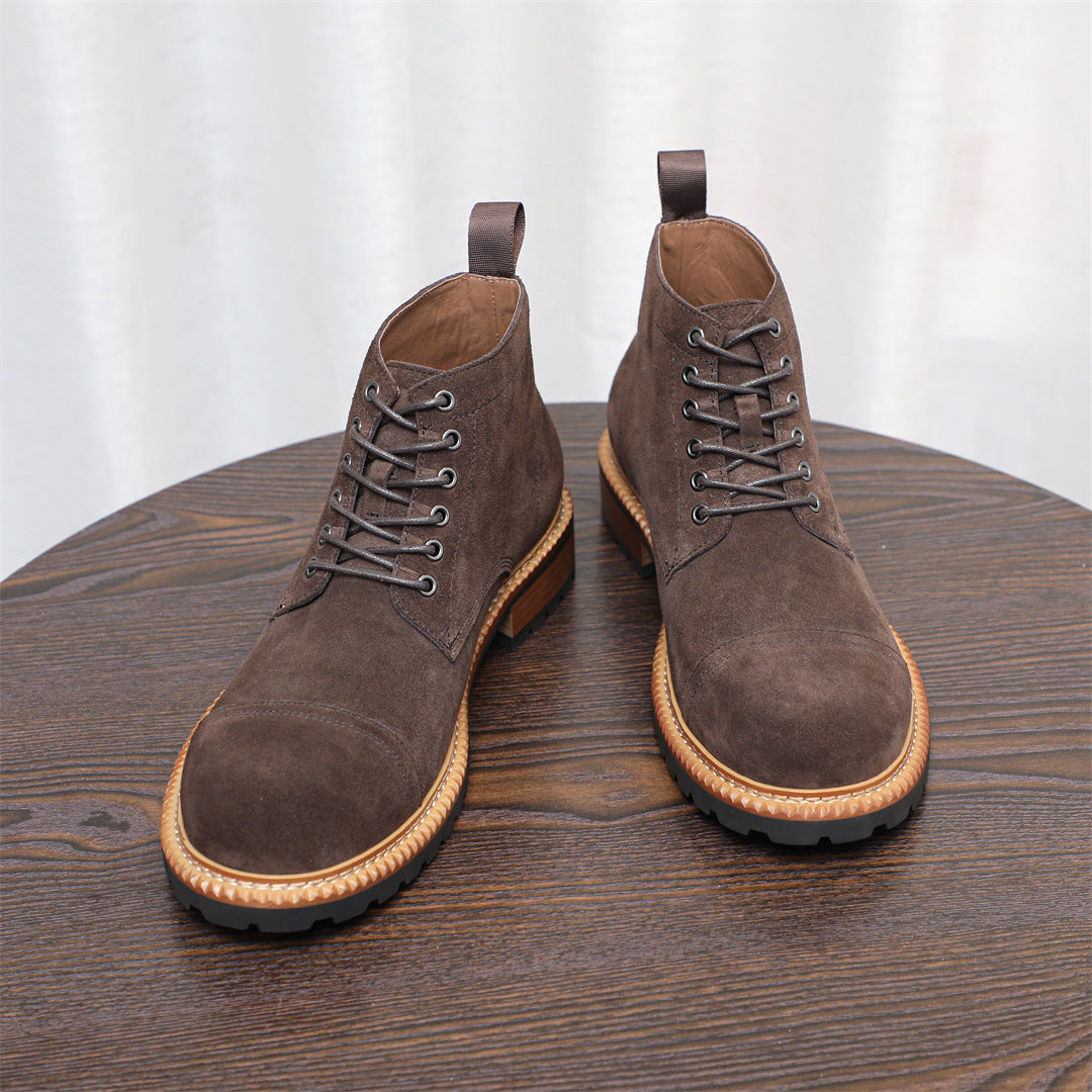 Pair of dark brown suede chukka boots with lace-up front and tan-trimmed sole