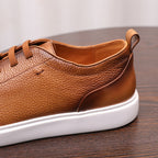 Brown leather sneaker side profile with lace area, padded collar, and white sole