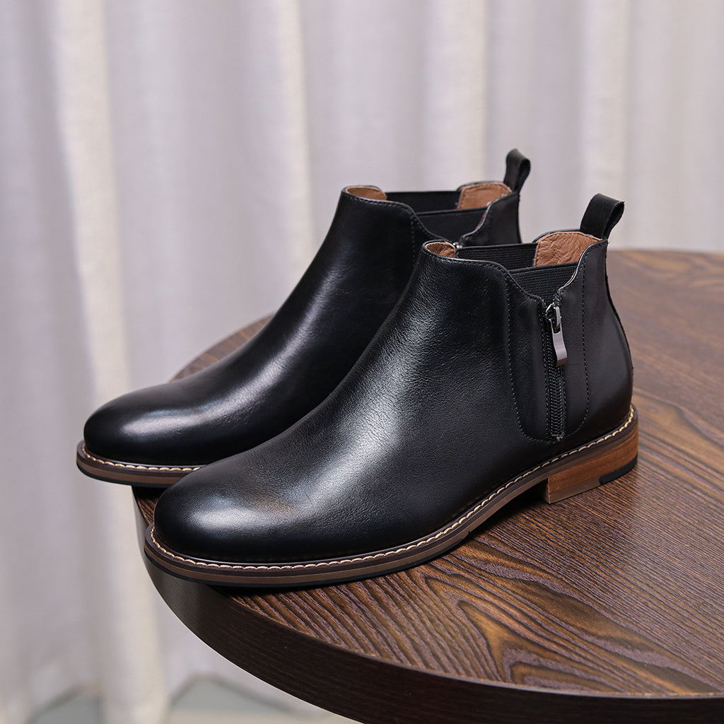 Black leather pointed-toe ankle dress boots with side zipper and stitched edge.
