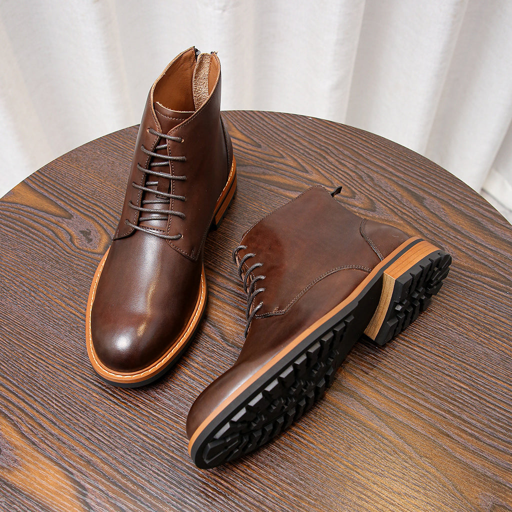 Dark brown leather pointed-toe boots with lace-up front, tan trim, and rugged sole tread