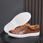 Men's tan leather sneakers outsole view with textured tread and white sole