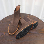 Dark brown suede chelsea boots with pointed toe and textured tread sole