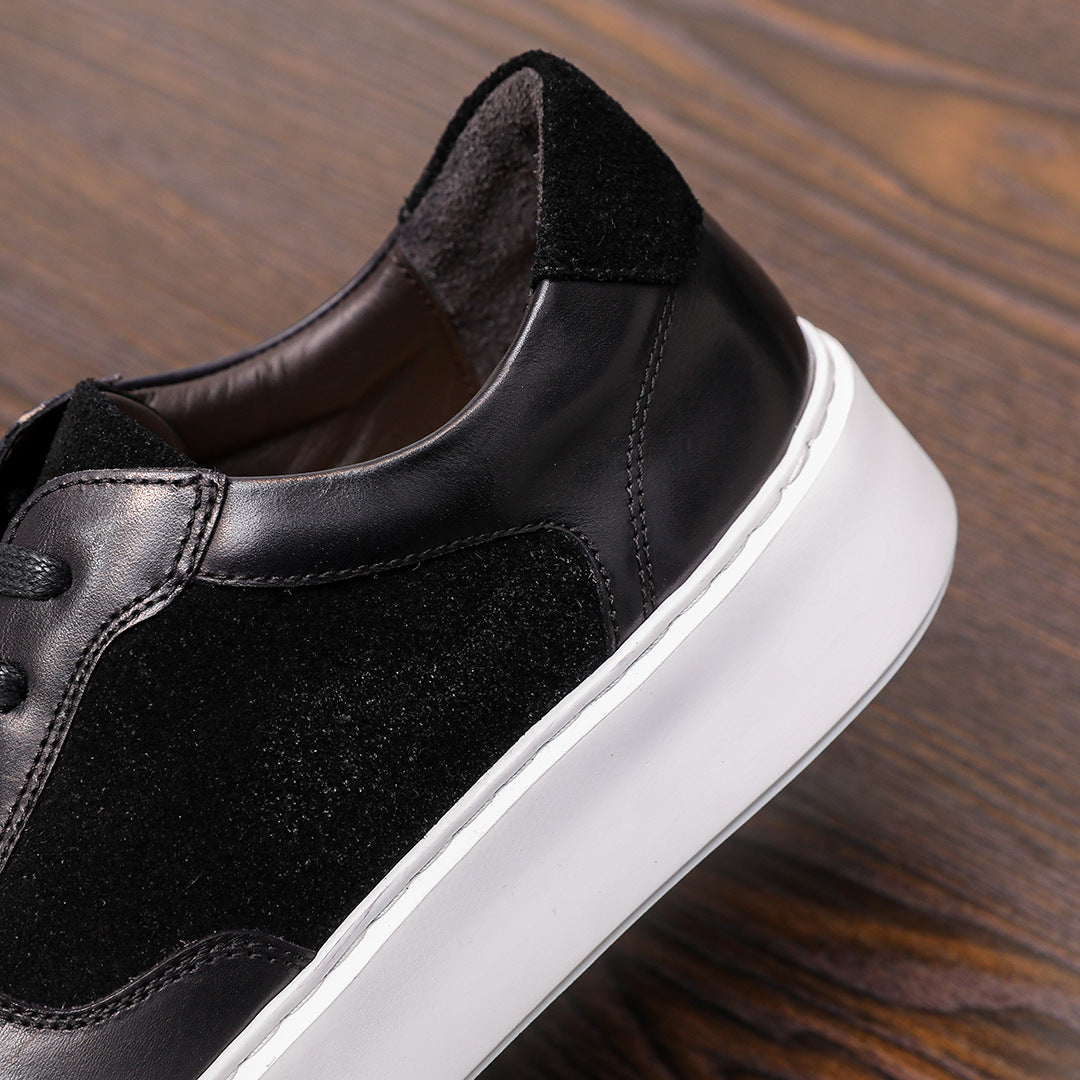 Black leather sneakers close-up at side and toe, stitched panels, white sole