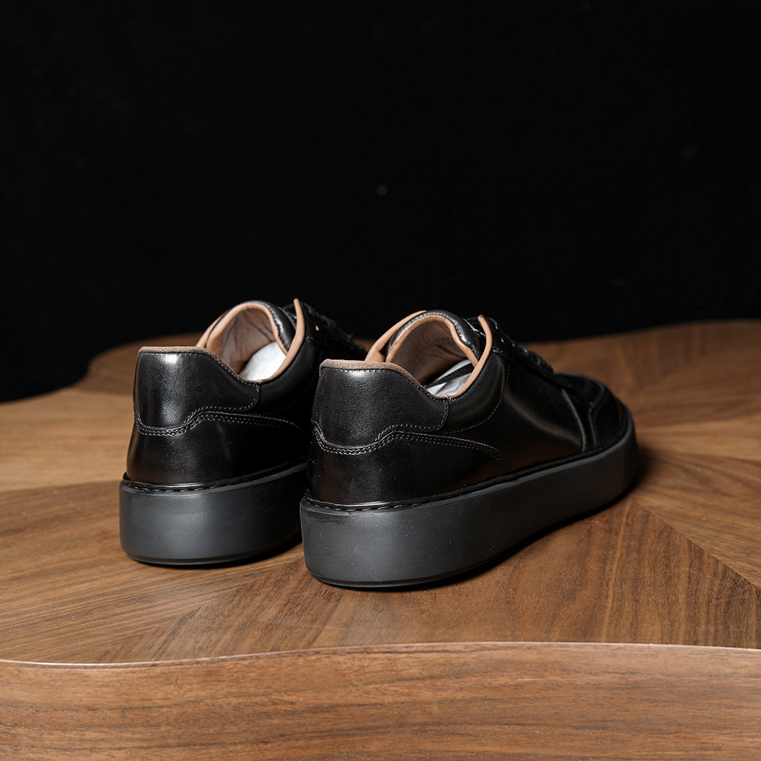 Black leather men's sneakers, rear view with cushioned heel and textured rubber outsole.
