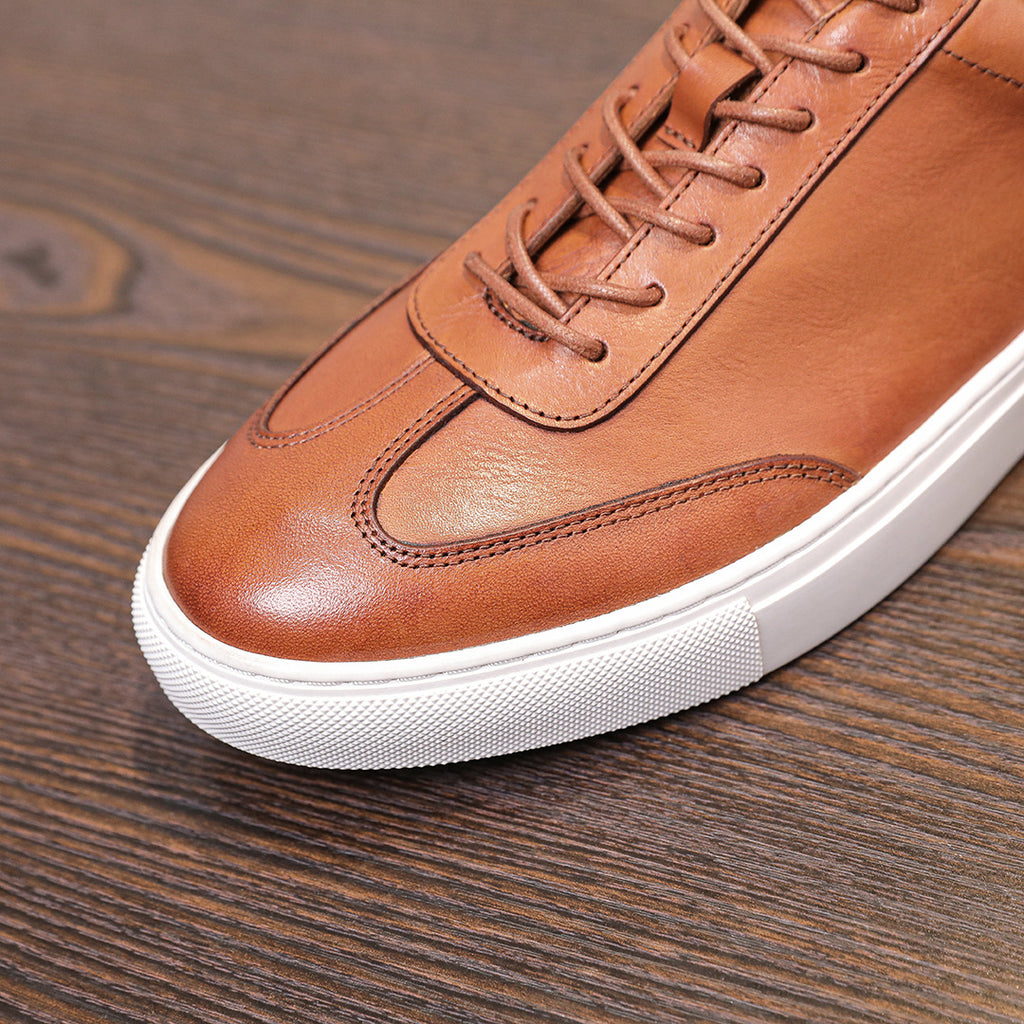 Brown leather lace-up sneaker with stitched toe cap and white rubber midsole