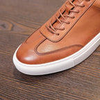 Brown leather lace-up sneaker with stitched toe cap and white rubber midsole