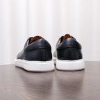 Back view of dark blue leather lace-up sneakers with white rubber sole