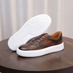Dark brown leather lace-up sneaker with white tread outsole and cushioned sole