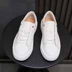 White leather low-top sneakers with lace-up front and white rubber sole