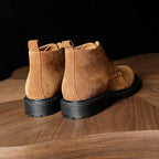 Men's suede chukka boots, plain toe, lace-up closure, dark rubber sole, tan color.
