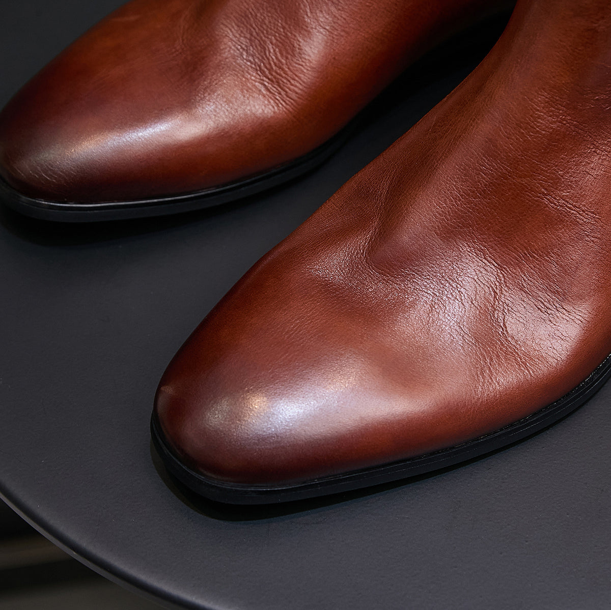 Brown pointed-toe Chelsea dress boots, upper and toe curve close-up